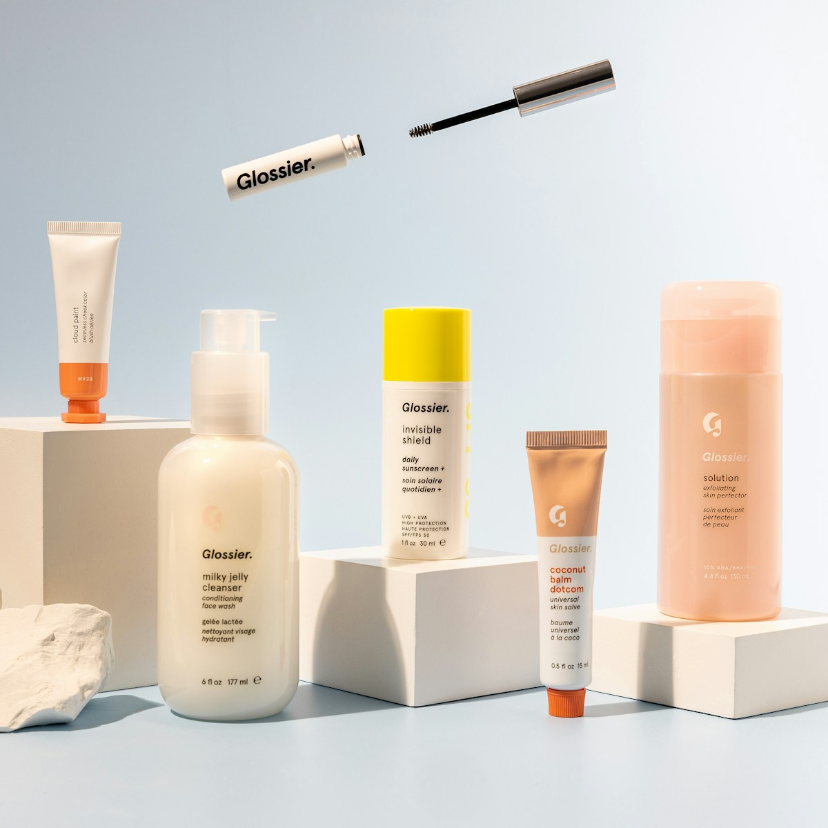 Témoignage haircare — produits blancs et bruns sur fond rose